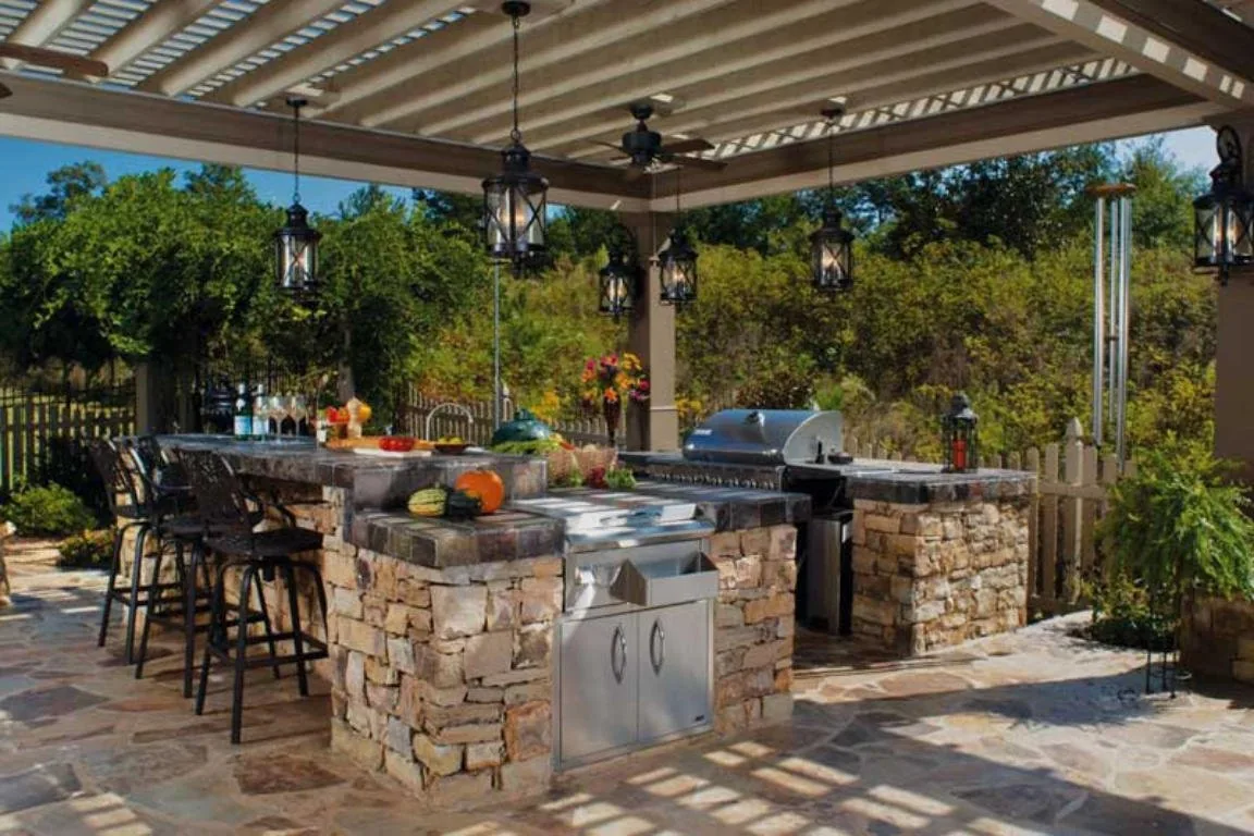 Outdoor kitchen with stone bar under a pergola