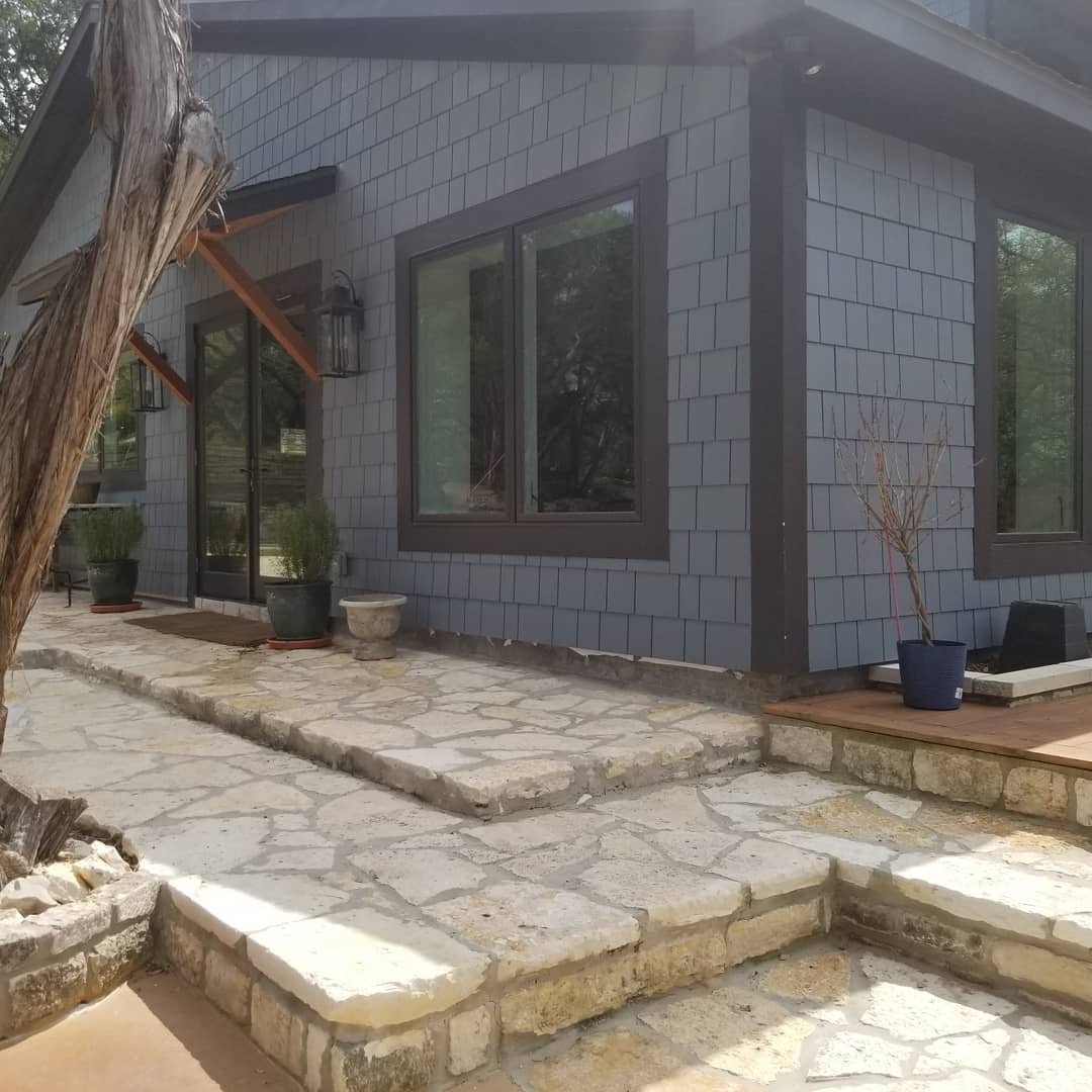 Stone patio addition on a shingle sided home