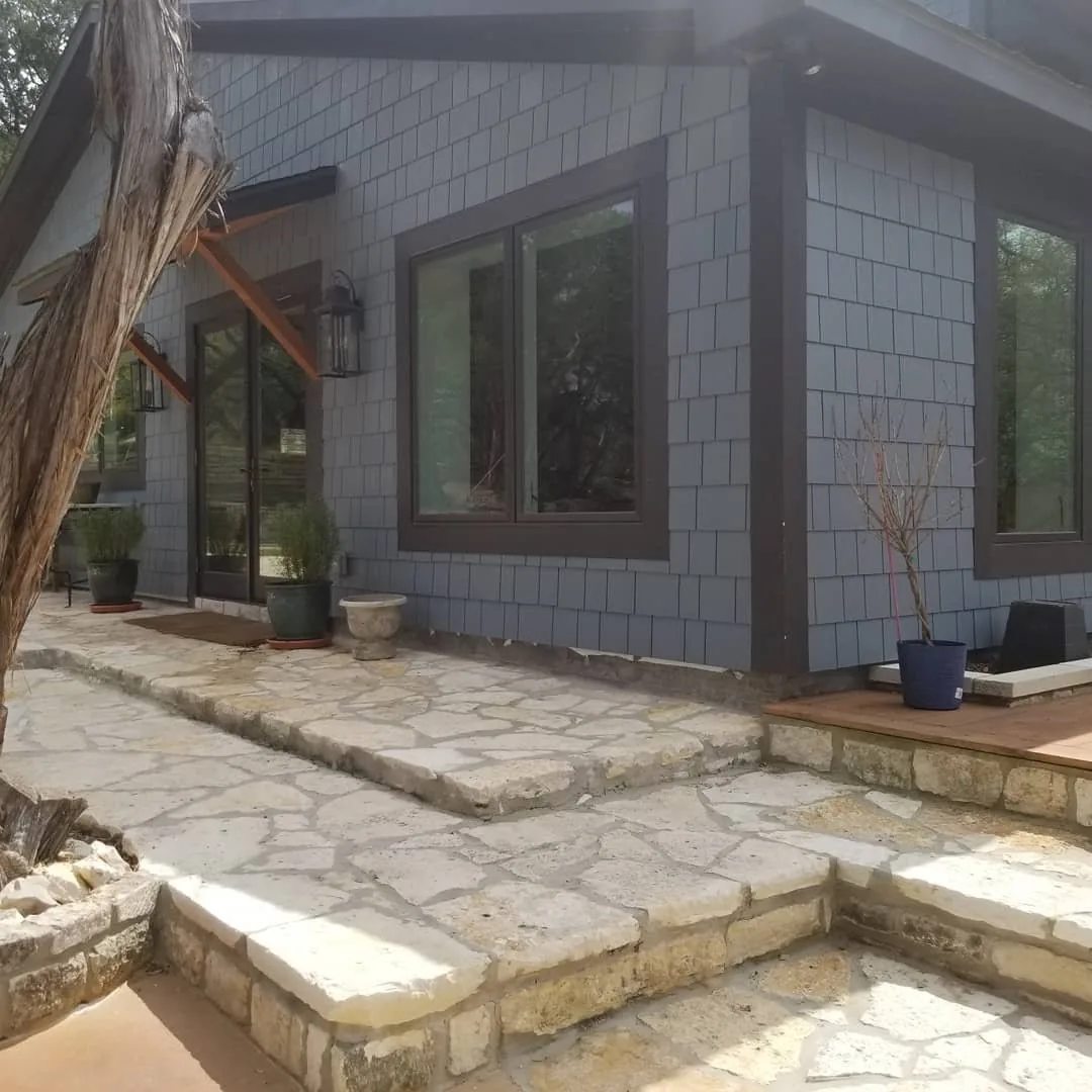 Stone patio addition on a shingle sided home
