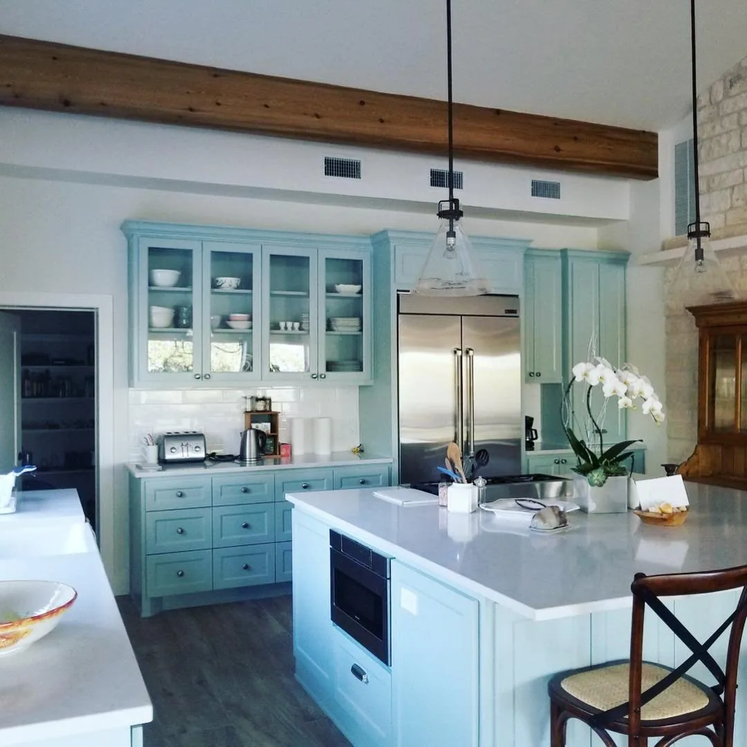 Custom kitchen with painted cabinetry and exposed beam