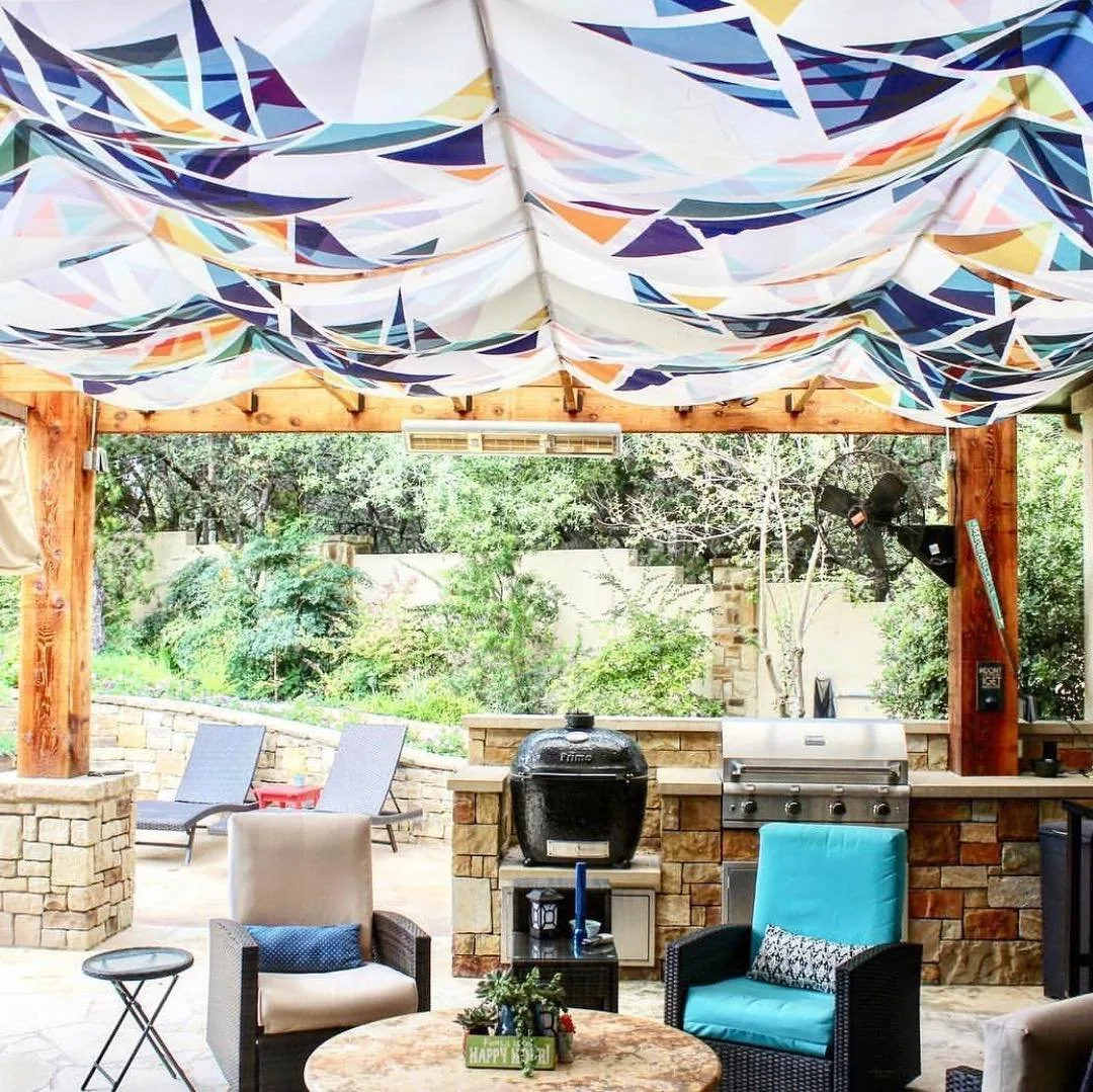 Covered outdoor kitchen and lounge with stone counters